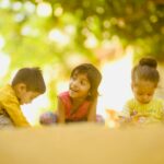 3 children sitting on white table during daytime