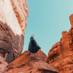 a person standing on a rock in the middle of a canyon